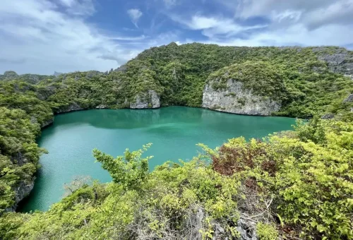 The stunning Emerald Lagoon surrounded by green cliffs at Angthong Marine Park.