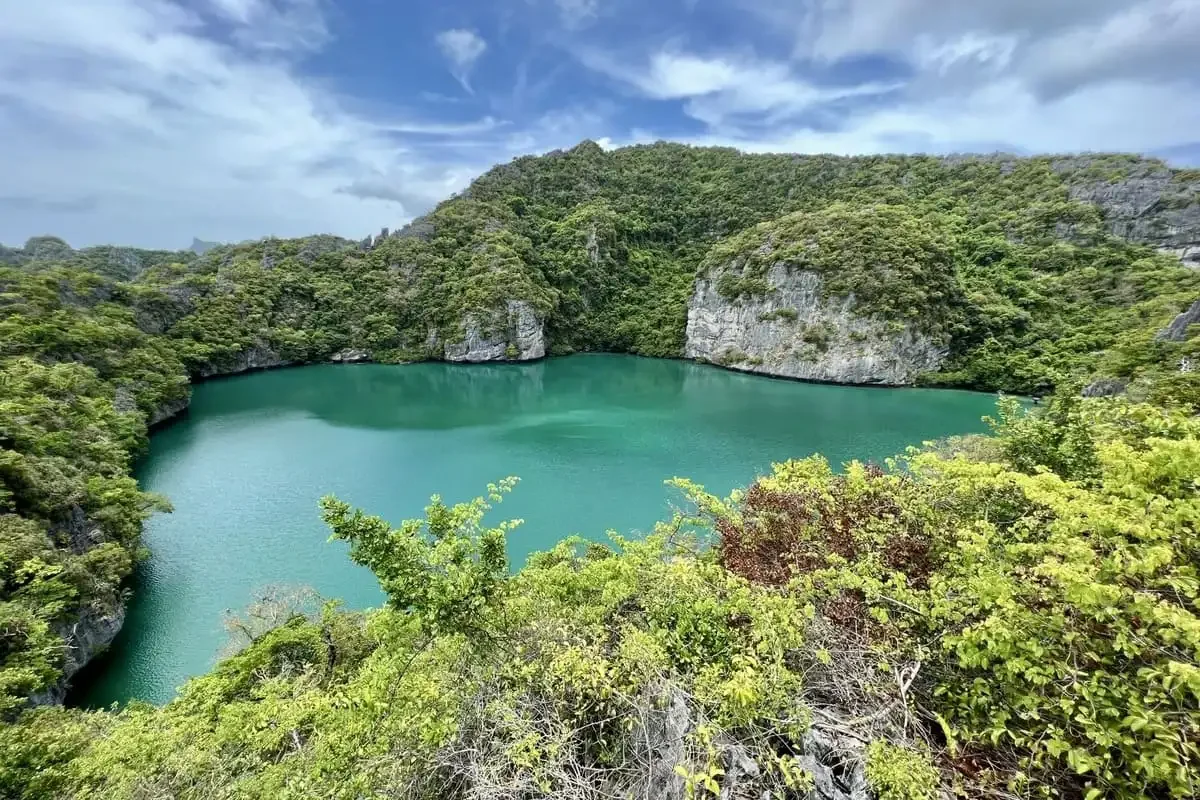 The stunning Emerald Lagoon surrounded by green cliffs at Angthong Marine Park.