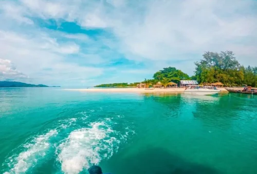 Scenic approach to Coral Island and Pig Island near Samui with turquoise water and tropical shoreline seen from the speedboat.