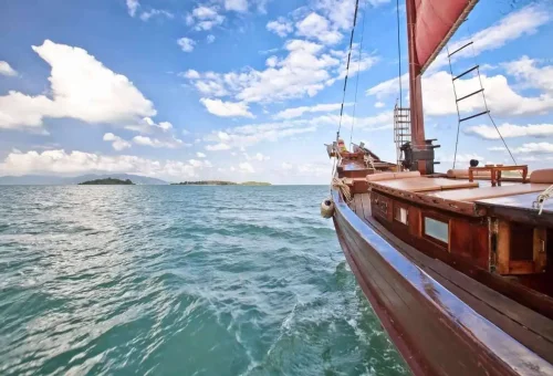 Traditional Thai wooden boat sailing across the Gulf of Thailand