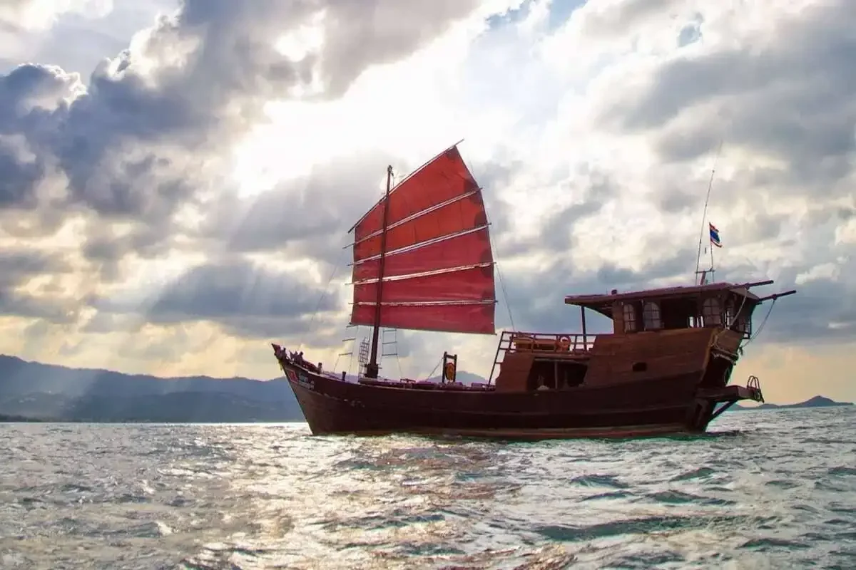 Traditional Thai junk with red sails sailing off Koh Samui