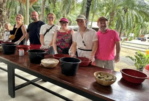 Group activity at Krabi Elephant Shelter showing visitors making elephant food balls.