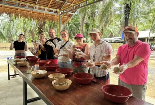 Group of travelers preparing elephant food at Krabi Elephant Shelter with Phuket Travel Store during the Cook and Feed activity.