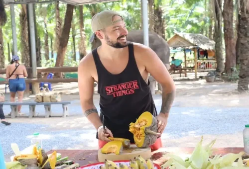Traveler cutting pumpkin for elephant meals during the Prepare and Feed program in Krabi.