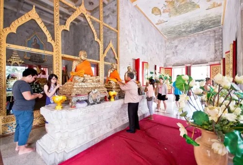 Private Phuket City Tour – visitors paying respects inside Wat Chalong temple during a cultural tour with Phuket Travel Store.