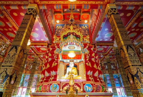 Private Phuket City Tour – richly decorated interior of Wat Phra Thong with golden Buddha statue and vibrant artwork in Phuket with Phuket Travel Store.
