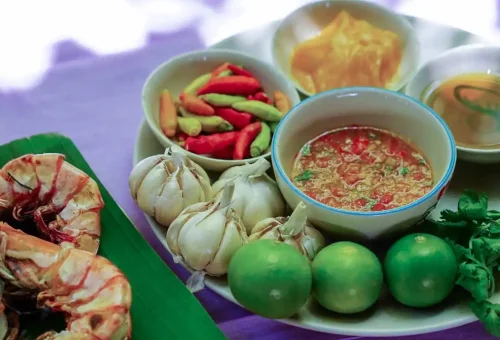 Fresh Thai ingredients including garlic, chilies, prawns, and lime used in the cooking class.