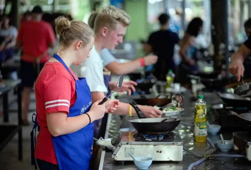 Teenagers cooking Thai dishes during a group class at Ya’s Thai Cookery School.