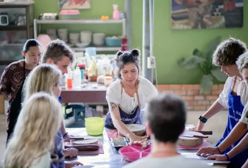 Instructor demonstrating food preparation to students at Ya’s Thai Cookery School.
