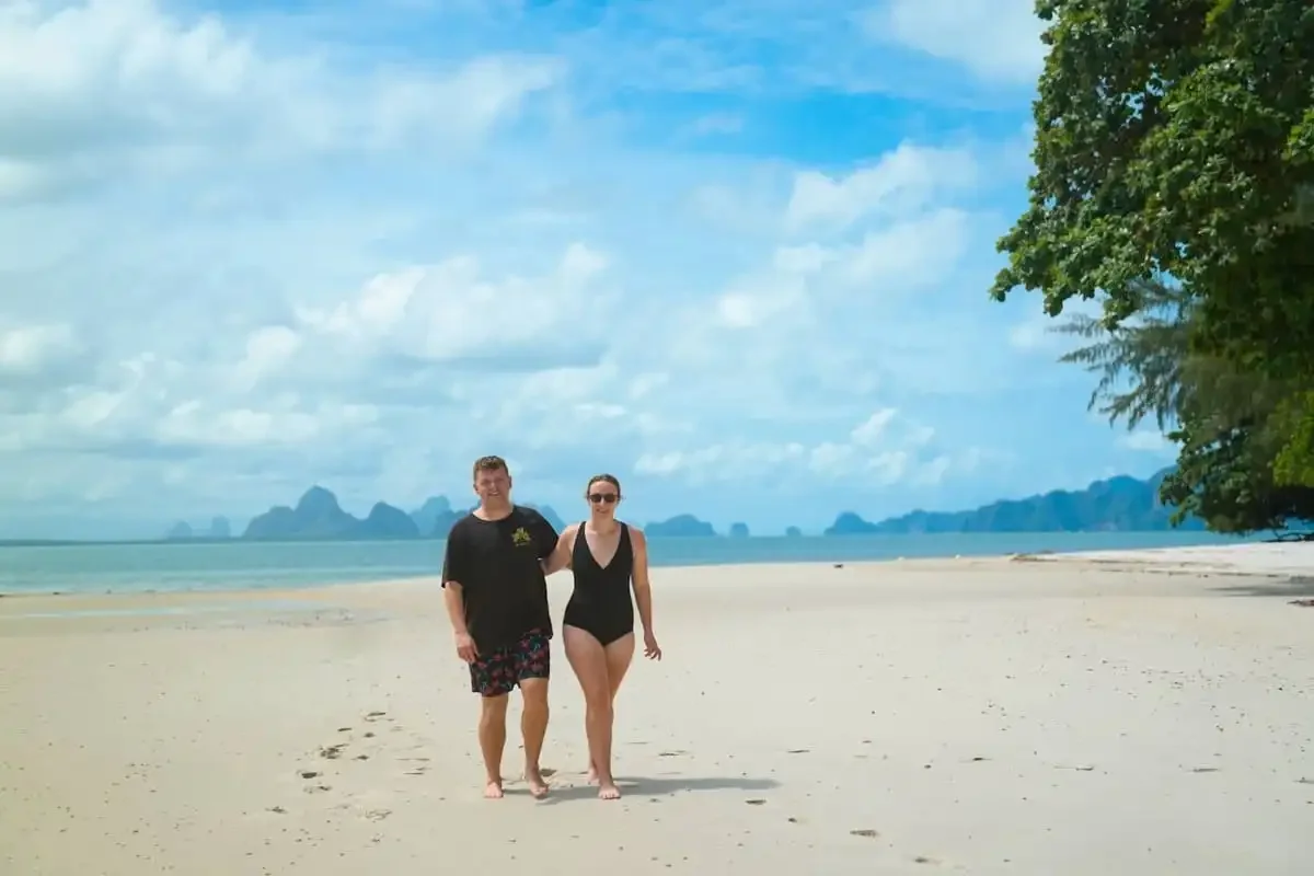 Couple walking on a quiet white-sand beach in Phang Nga Bay on a private island-hopping experience