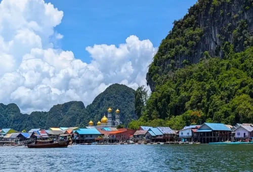 Colorful floating village of Koh Panyee with mosque domes in Phang Nga Bay on a private tour.