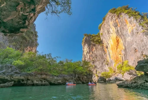Kayaking in a hidden lagoon surrounded by towering limestone cliffs in Phang Nga Bay.