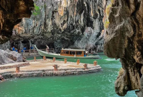 Traditional longtail boat arriving at a hidden cave pier inside Phang Nga Bay on a private tour.