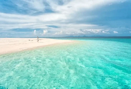 Man walking on a remote sandbank near Phi Phi on a private speedboat charter.
