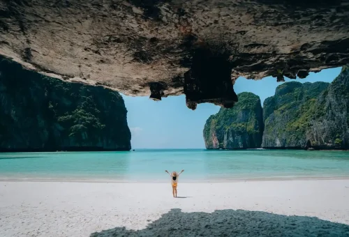 Traveler standing on the white-sand beach inside Maya Bay on a Phi Phi private speedboat excursion.