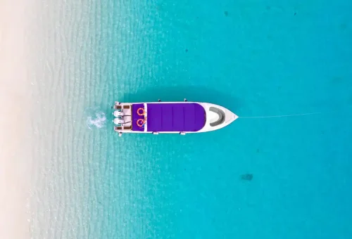 Aerial view of a private speedboat anchored in shallow turquoise water near Bamboo Island.