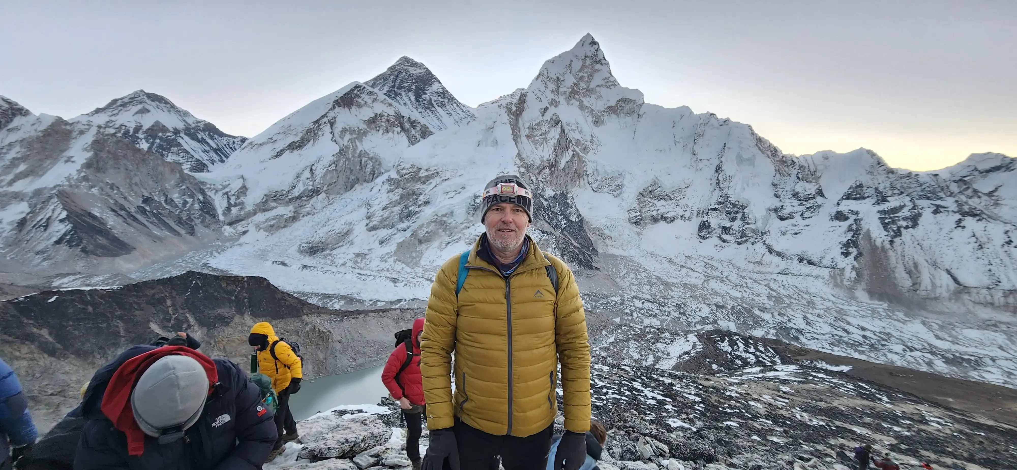 Our guest, Paul Digby stands at tha Kalapatthar viewpoint at dawnwith Mt. Everest, Nuptse and Pumori in the background.
