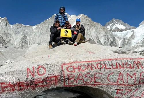 Trekkers celebrating in front of the iconic Everest Base Camp stone marker after completing the trek - Nepal Visuals