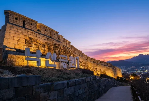 Sunset over Seoul's historic city wall and skyline on a B2K Hidden Heights evening walking tour